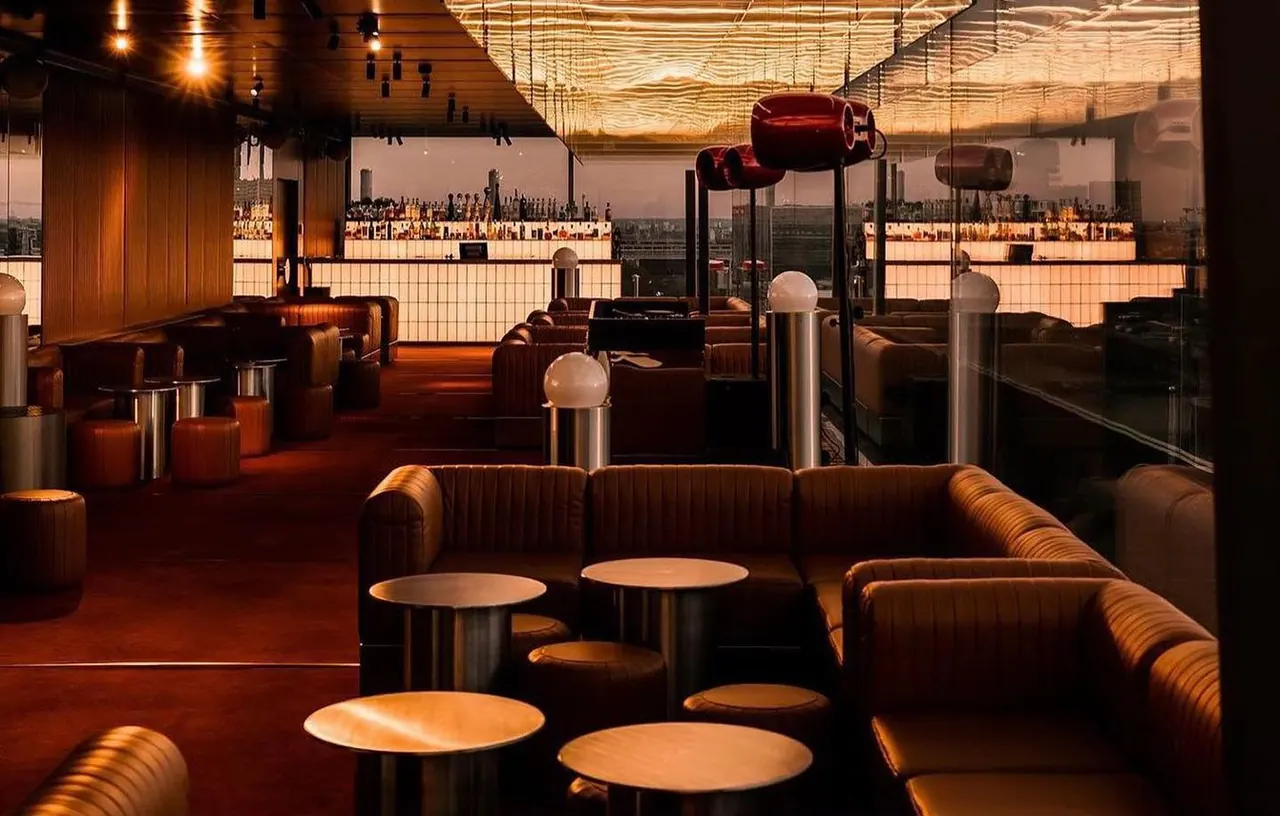 Intimate rooftop nightlife lounge with warm lighting at dusk