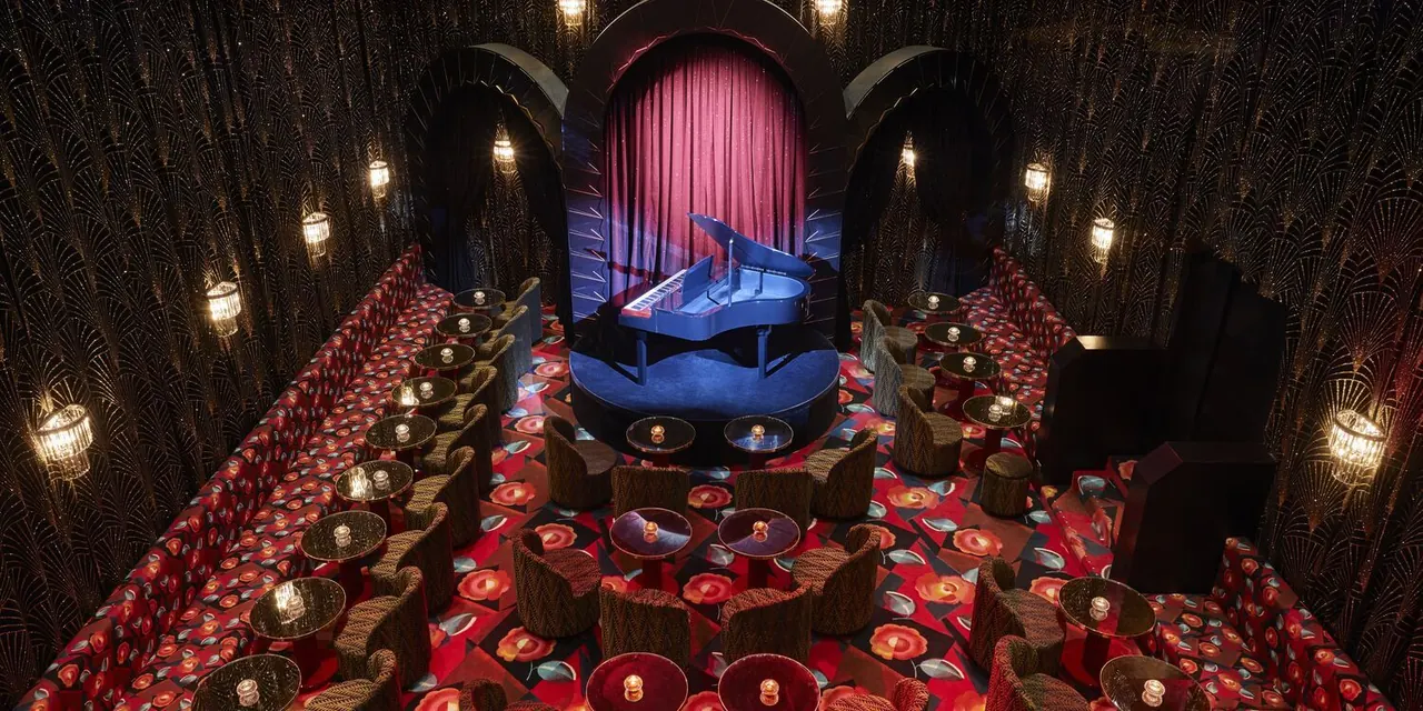Art Deco-style private lounge with a grand piano on a lit stage
