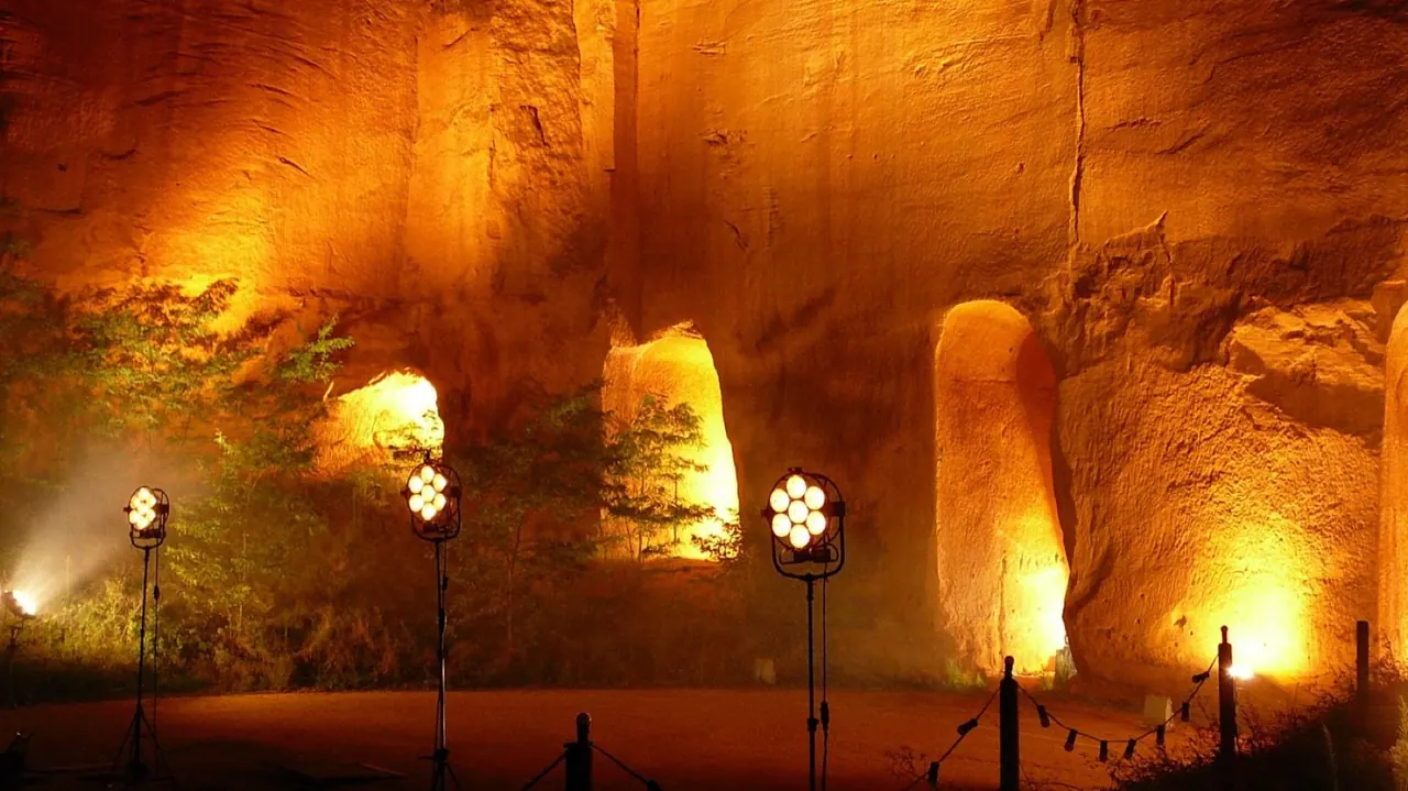 Illuminated ochre quarry walls set up for an evening event