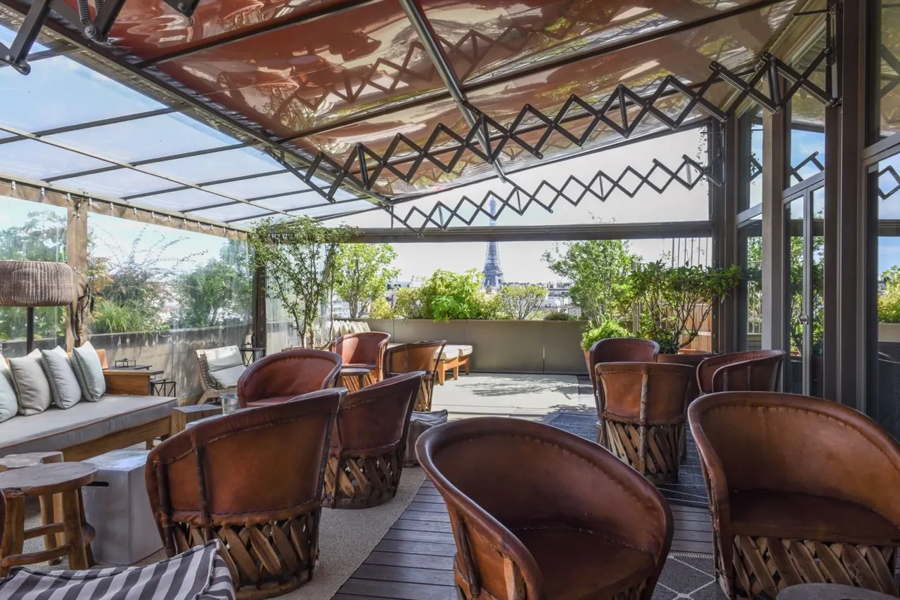 Rooftop terrace lounge with a landmark Paris tower visible in the distance