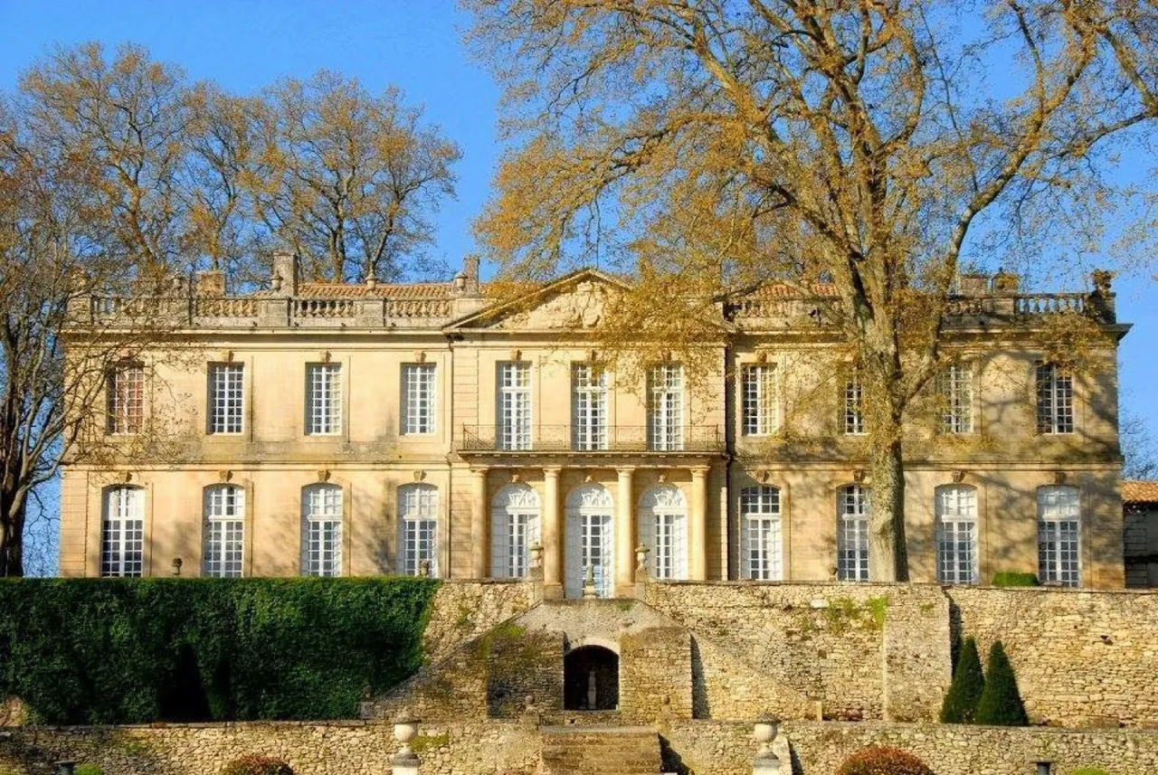 Grand 18th-century French chateau facade framed by autumn trees