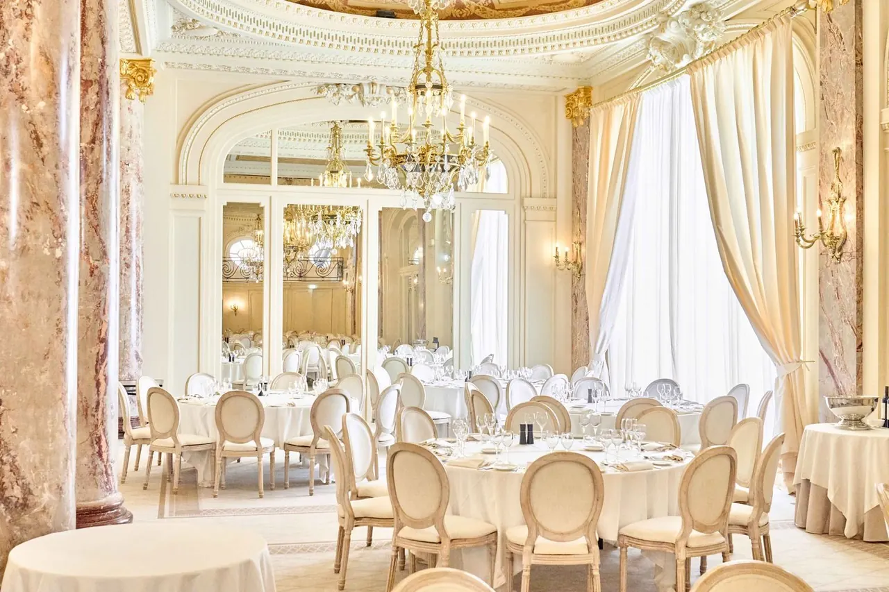 Sunlit belle-epoque salon with marble columns set for a seated dinner