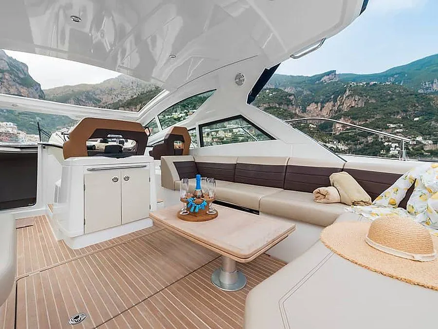 Sundeck lounge aboard a motor yacht overlooking an Amalfi Coast town